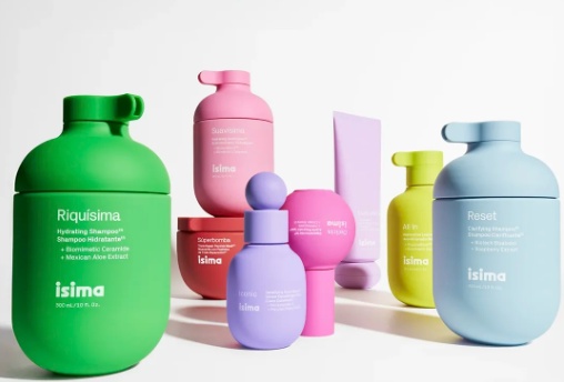Fotografia de vários frascos coloridos da linha Isima, em tons de verde, rosa, azul, roxo e amarelo, exibidos em diferentes formatos e tamanhos, cada um representando um tratamento específico para os cabelos. O design moderno e vibrante transmite jovialidade e inovação, destacando a proposta de cuidados completos para hidratar, reparar e fortalecer os fios. Essa coleção de cosméticos reforça o prestígio do produto capilar da Shakira, que faz parte da linha Isima, voltada para quem busca resultados profissionais em casa.