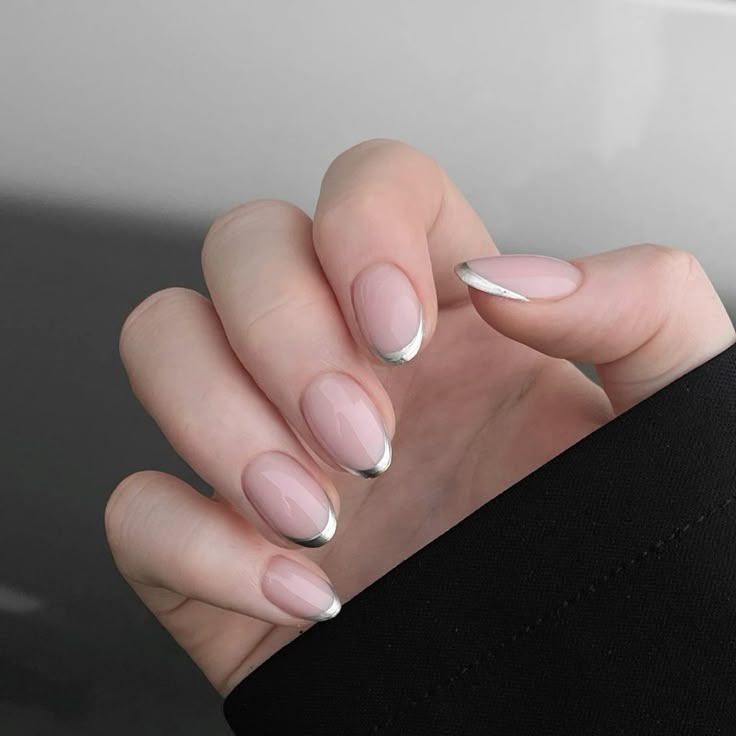 Unhas com esmalte em gel e francesinha moderna em tom metálico prateado.